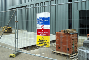 stack of red bricks, scaffolding and danger sign