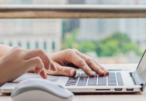 hands typing at laptop