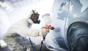 man spray painting a car